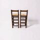 Set of 2 vintage wooden bar stools with woven straw seats.