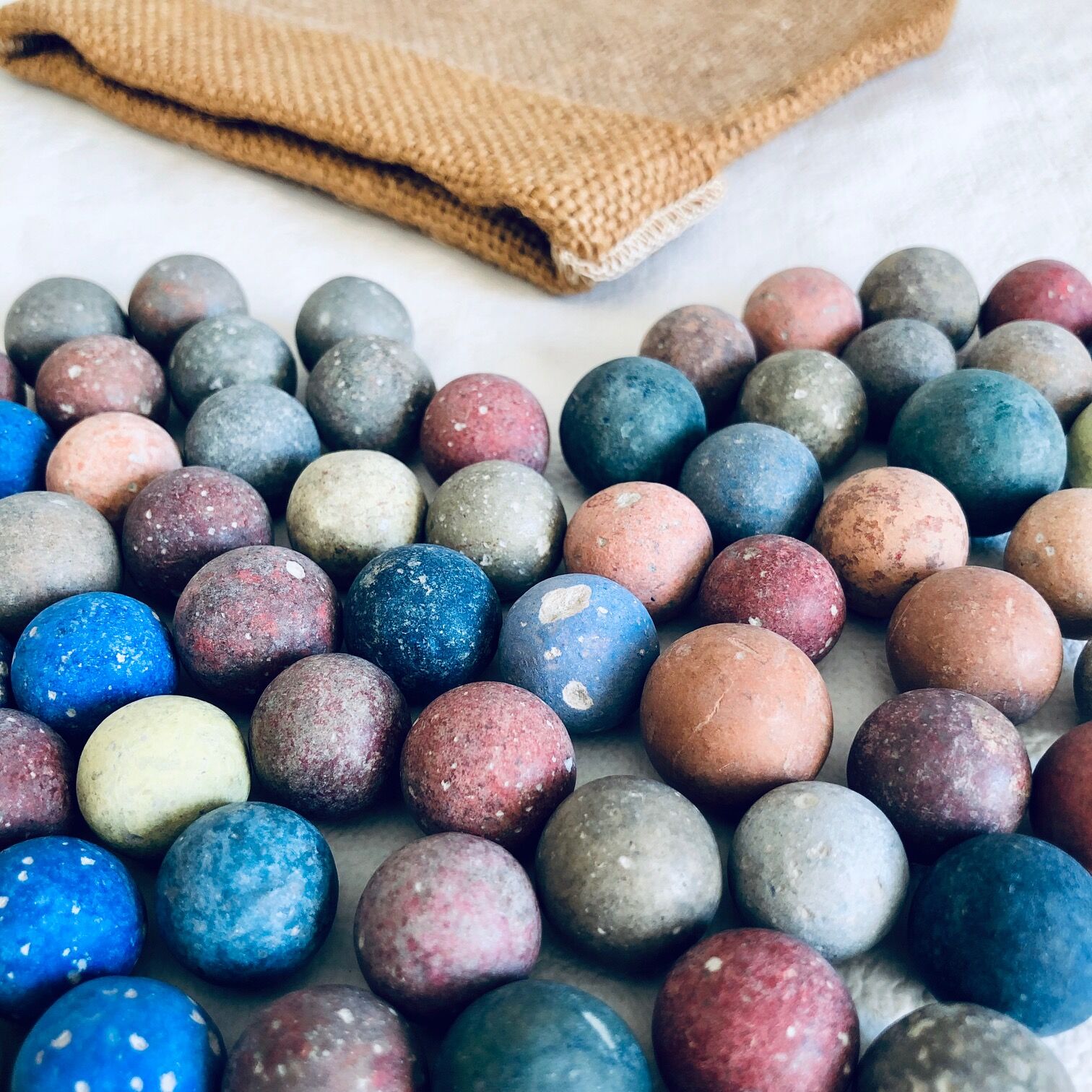 70 clay marbles and burlap bag