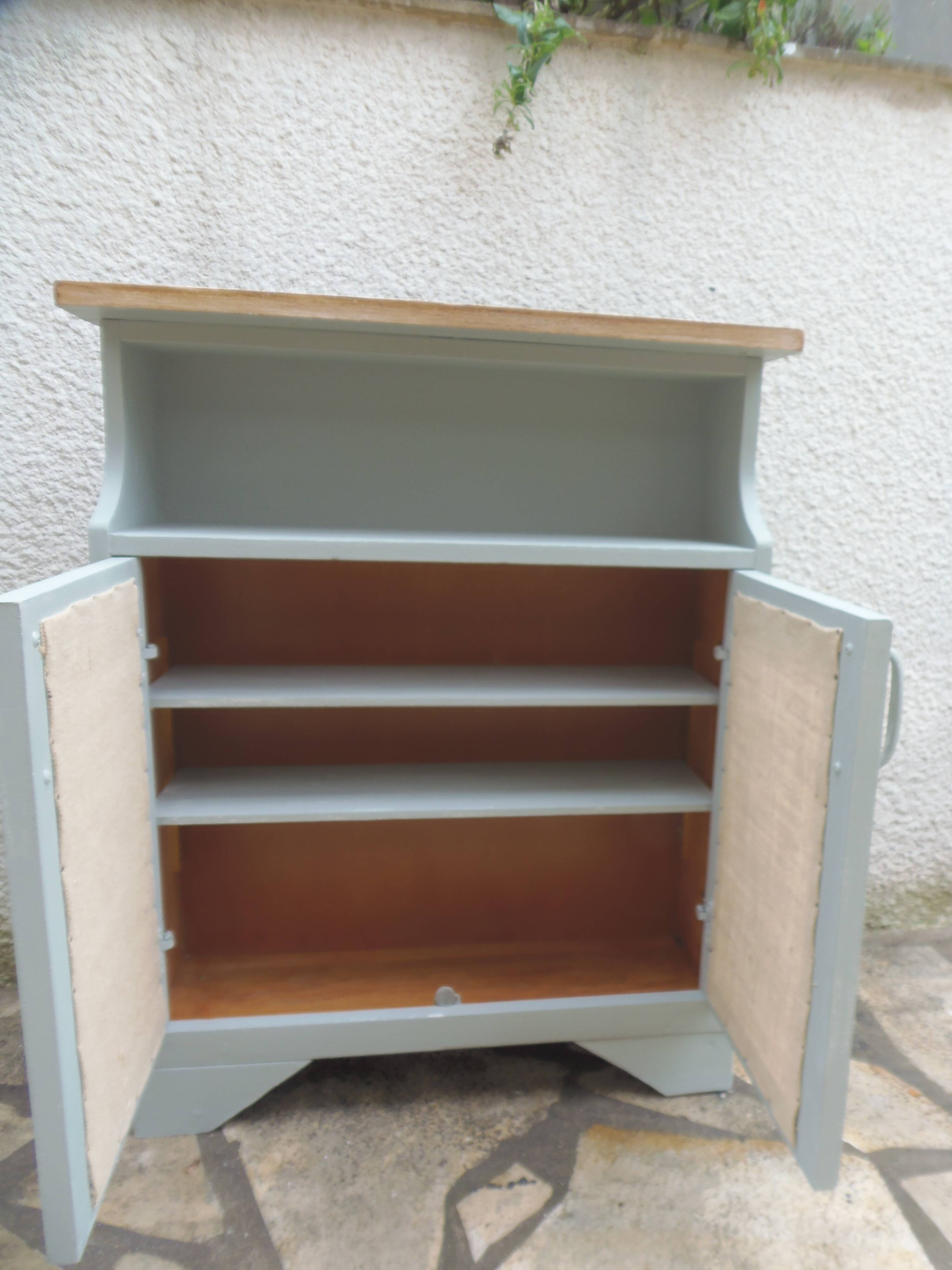 Small vintage green-grey piece of furniture, with 2 doors covered in burlap.