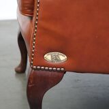 Elegant, smooth, and comfortable English Chesterfield wingback armchair in a beautiful classic color