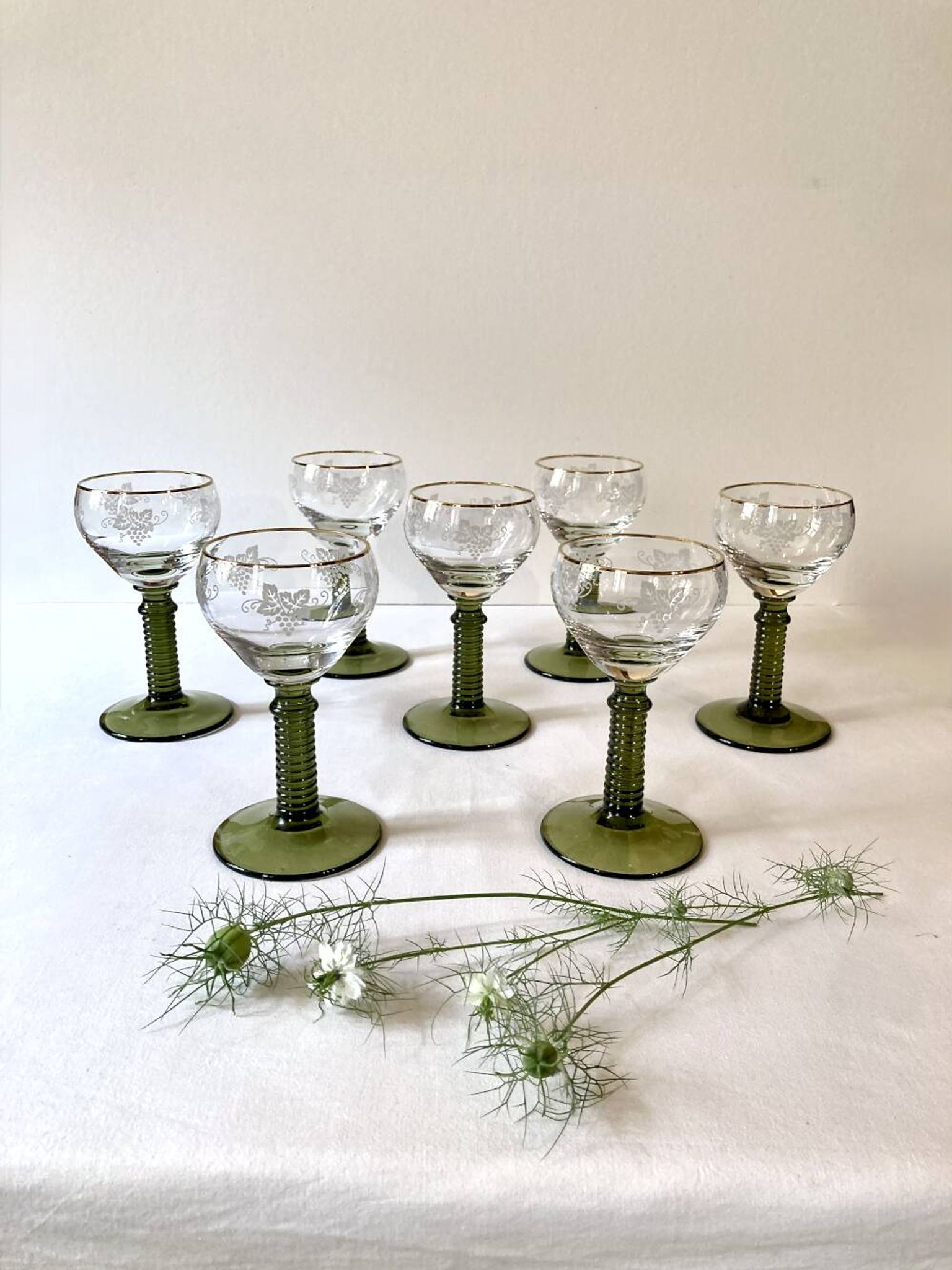 7 Alsace Roemer wine glasses, moss green stepped bases and gold trim.