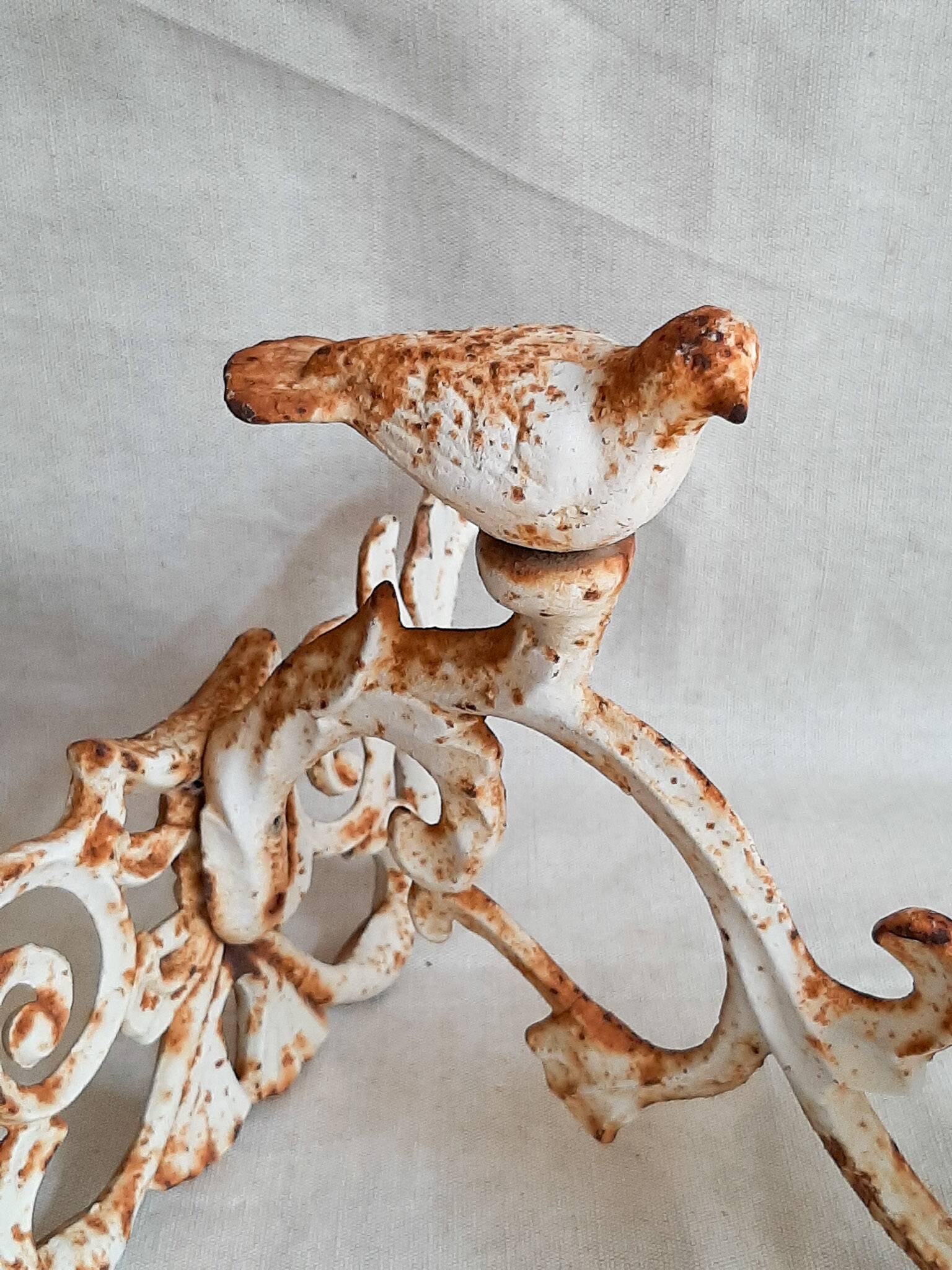 Wall lamp in antique cast iron with bird and scroll decorations.