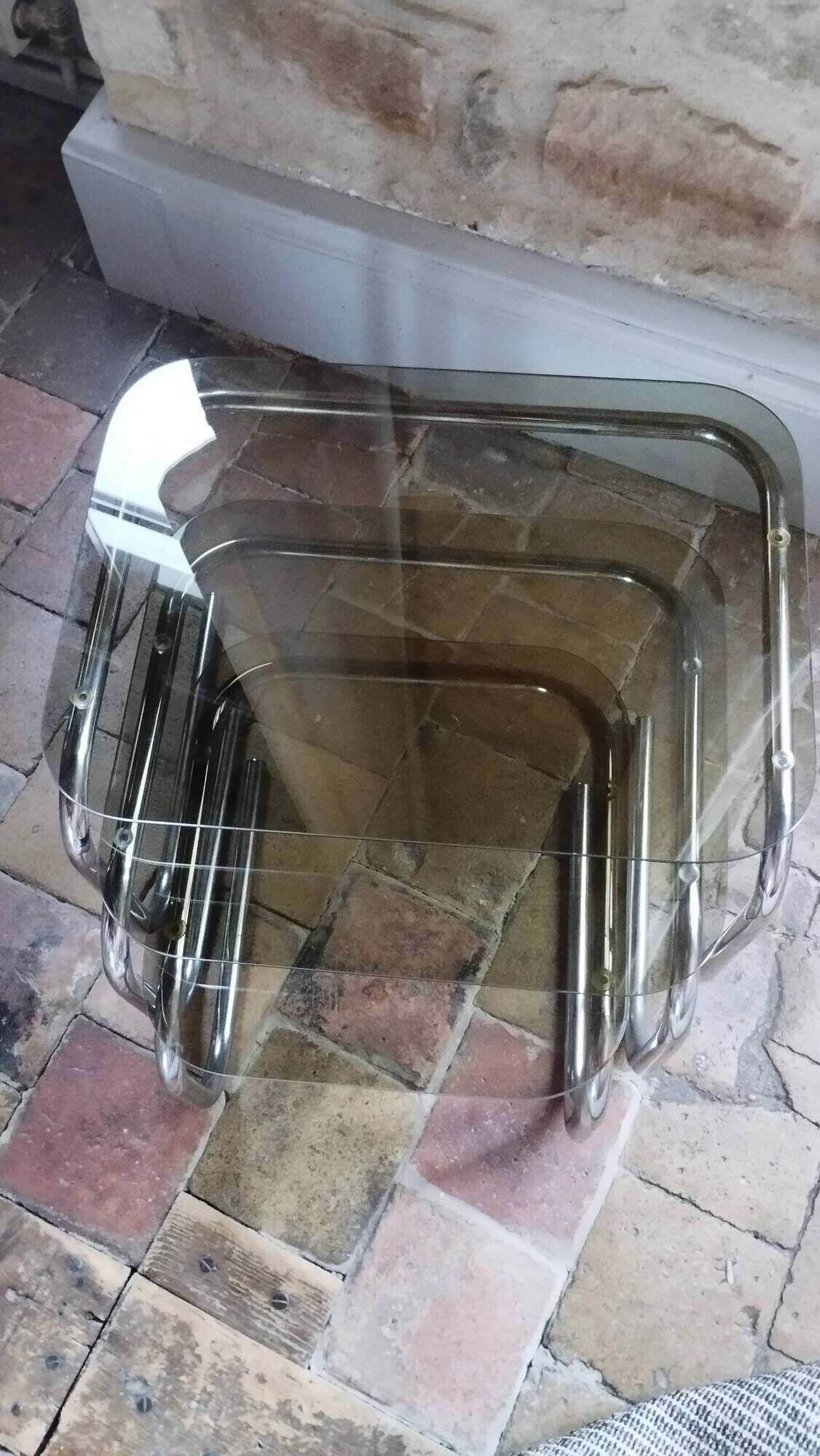 Nest of tables in glass and chrome steel.