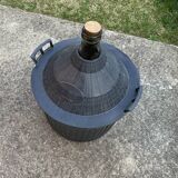 Dame-Jeanne vintage in olive green glass with a basket and black plastic lid.