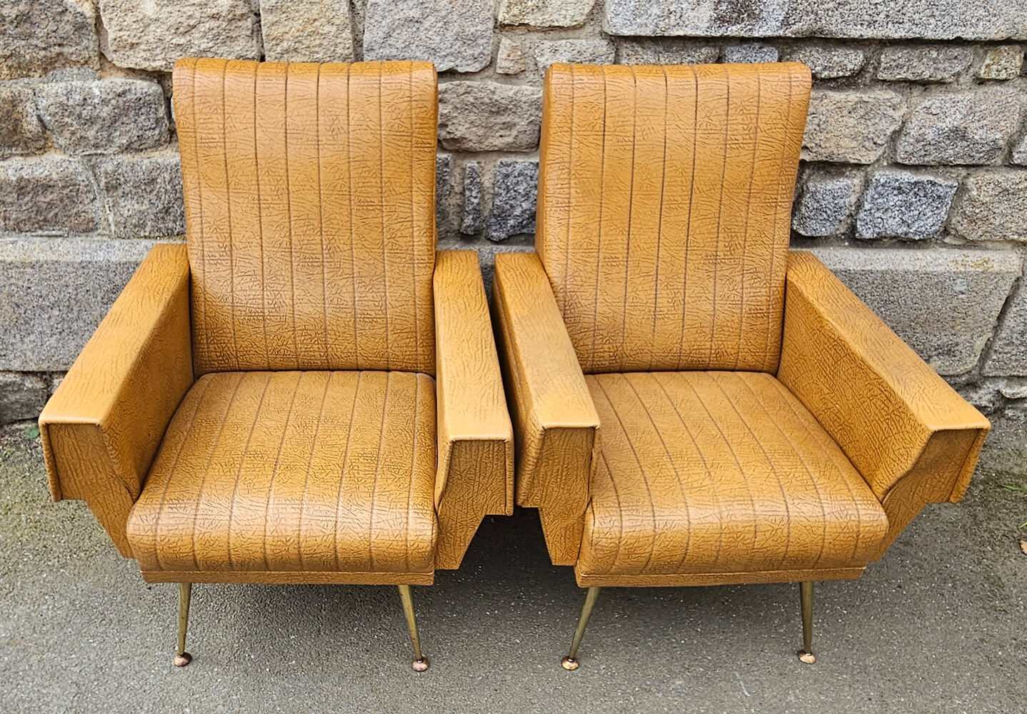 Pair of mustard skaï armchairs, brass feet