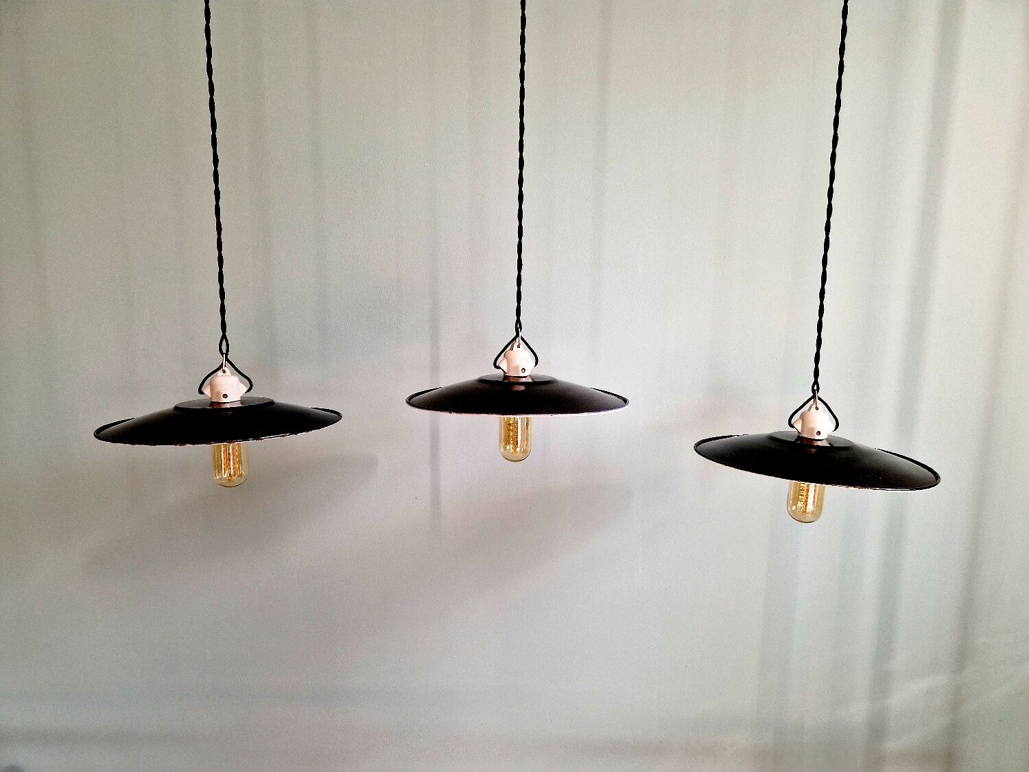 Three industrial suspensions in black enamelled sheet metal.