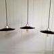 Three industrial suspensions in black enamelled sheet metal.