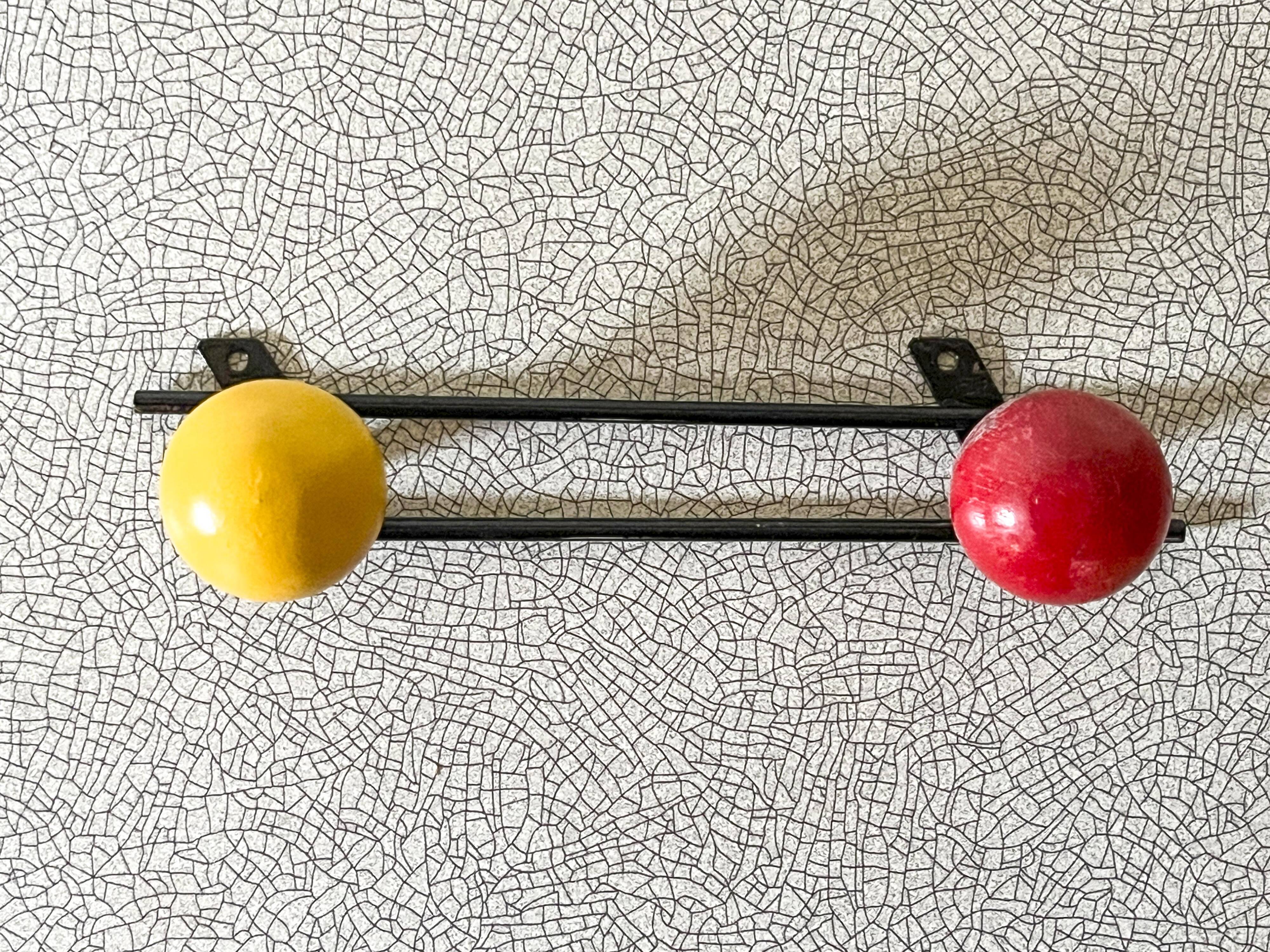 Vintage wall coat rack, metal and wood in yellow and red.