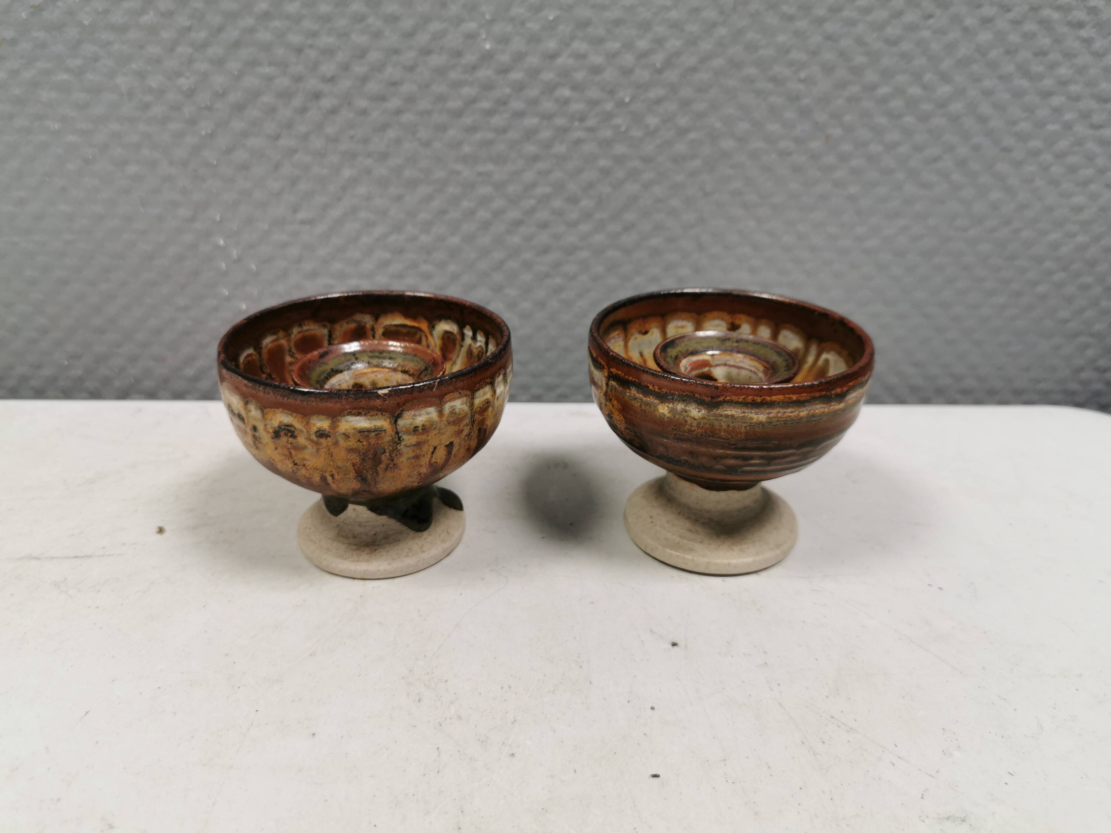 A set of ceramic candle holders in earthy colours.