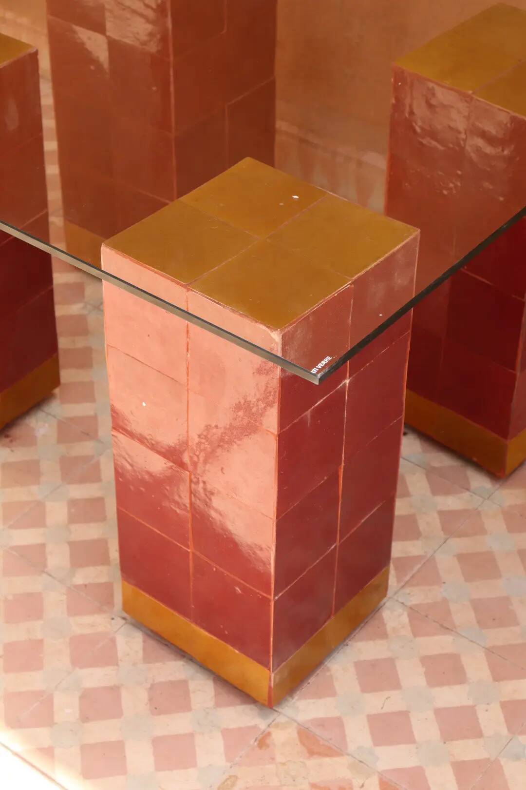 Modern coffee table in burgundy zellige with a tempered glass top.