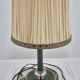 Brass table lamp with green patina and empire-style fabric shade.