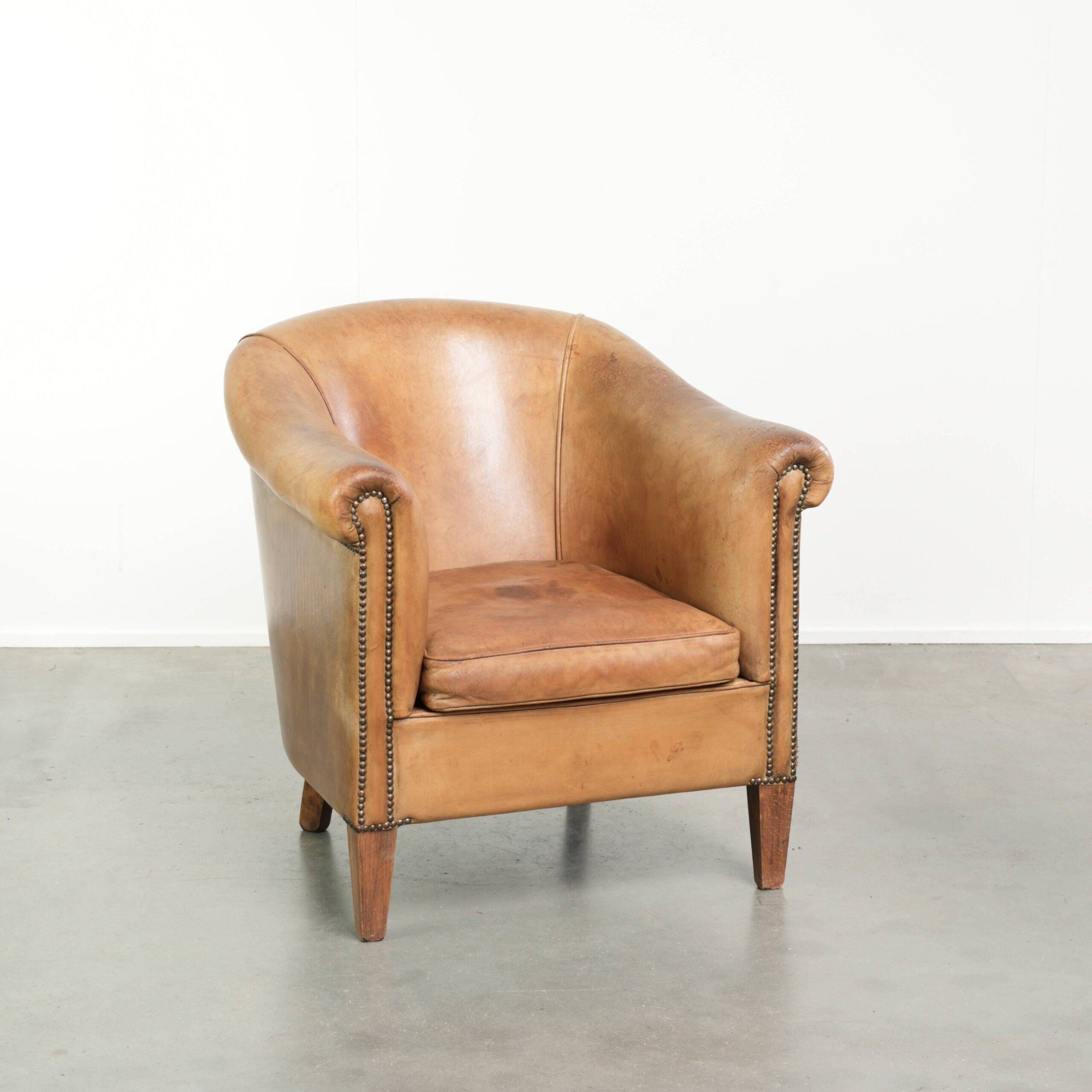 Fauteuil club en peau de mouton confortable de couleur cognac.