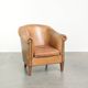 Fauteuil club en peau de mouton confortable de couleur cognac.