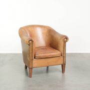 Comfortable sheepskin club armchair in a cognac colour