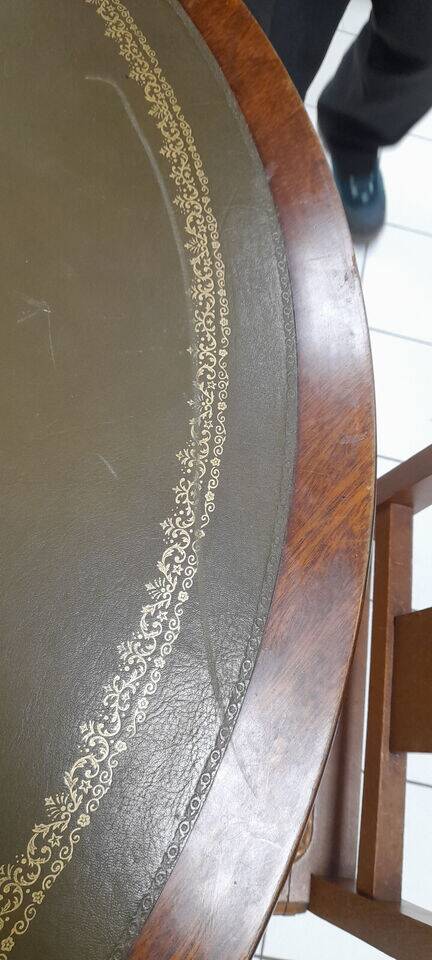 English style round table with green and gold leather top, quadripod with brass claws