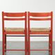 Set of two red vintage wooden chairs from the 1970s with woven rattan seats