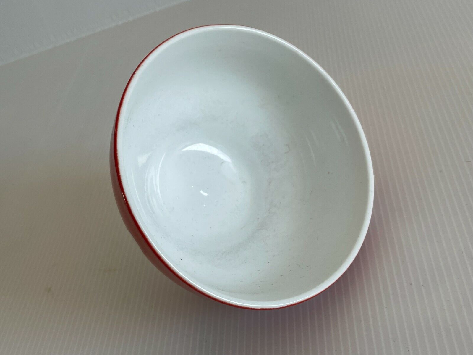 Red bowl with white polka dots signed Longchamp Porcelaine France