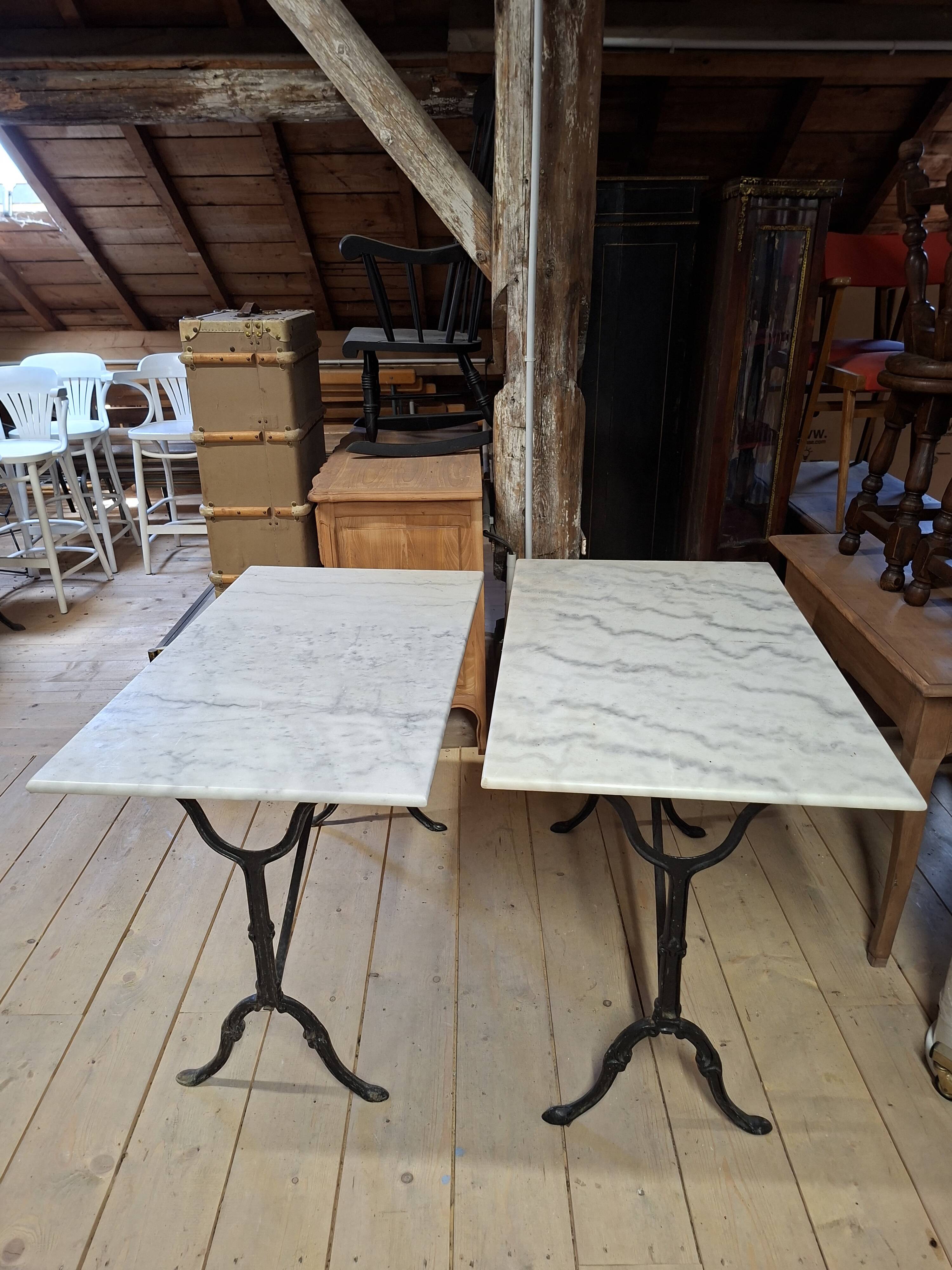 Pair of bistro tables in marble and cast iron.