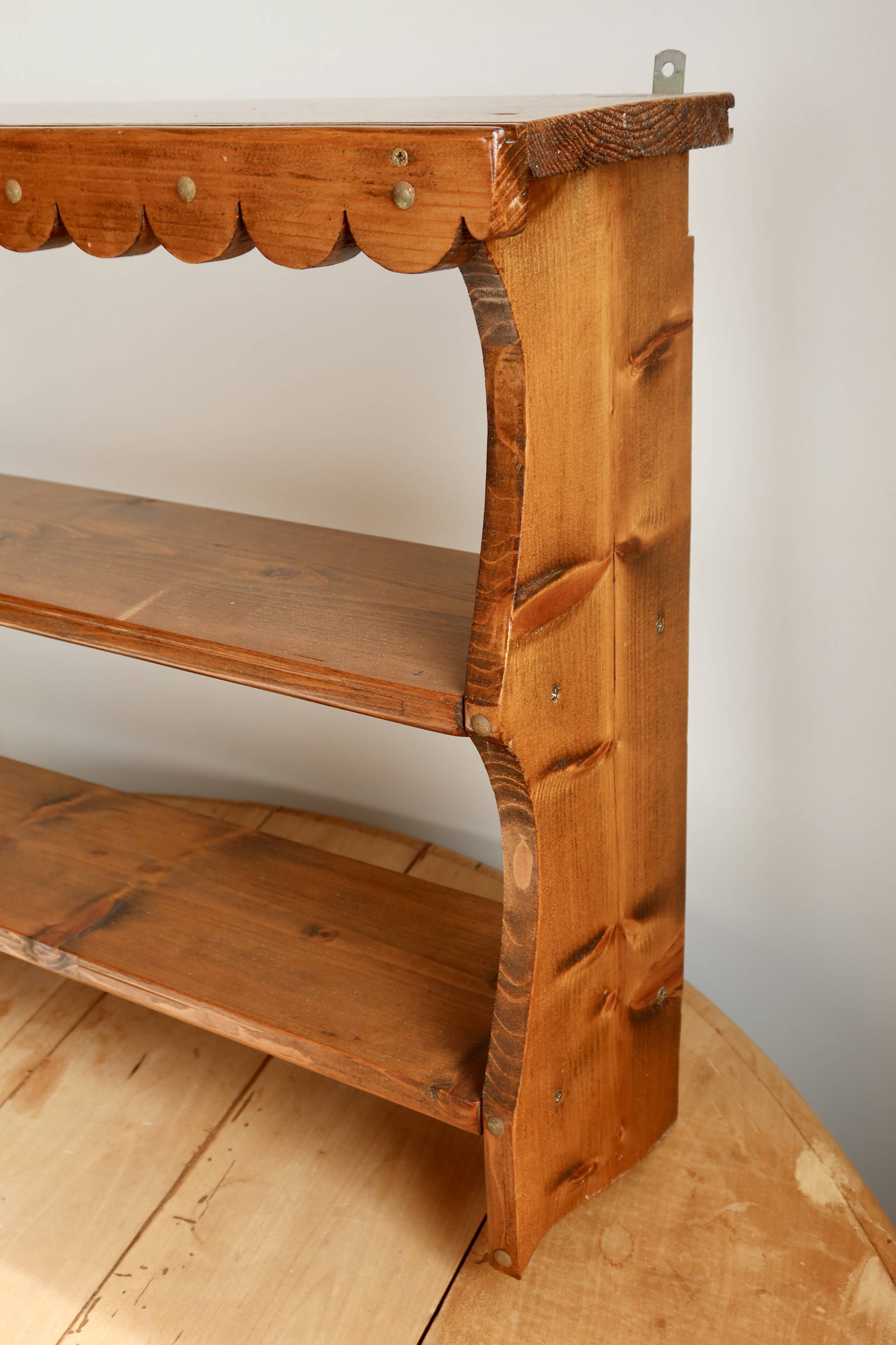 Vintage pine wall shelf with a scalloped front.