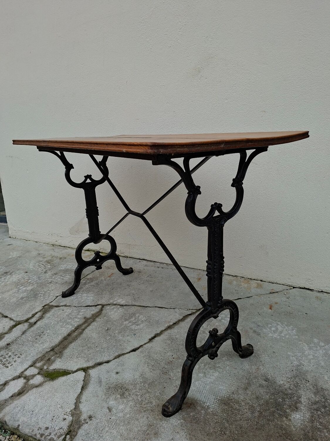 Solid oak bistro table with a cast iron base, signed.