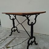 Solid oak bistro table with a cast iron base, signed.