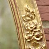 Old large oval wall mirror in golden resin