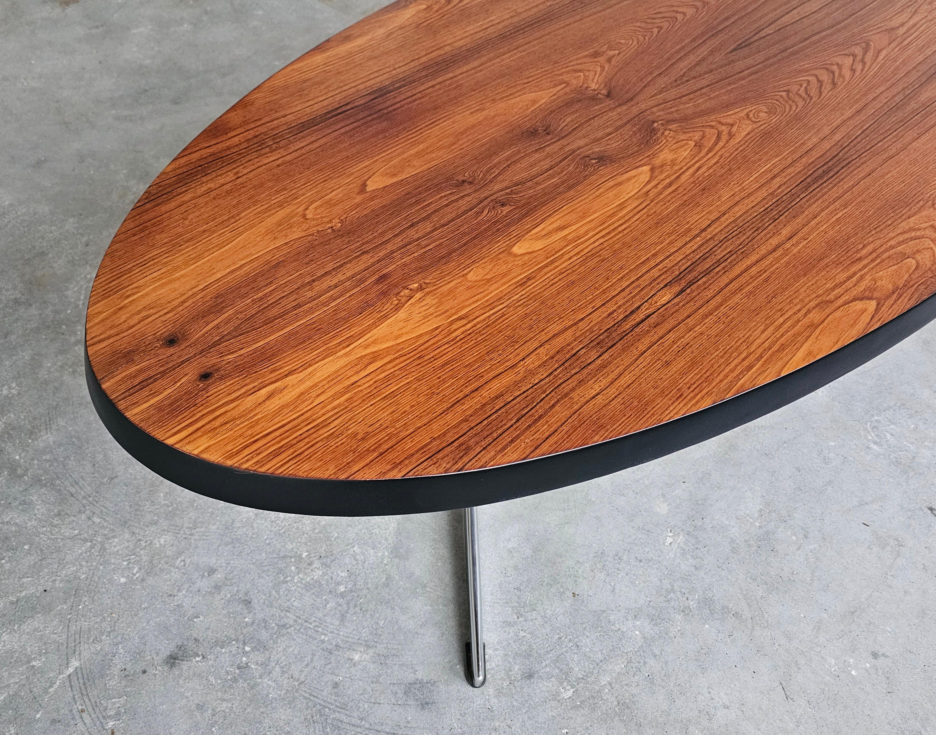 Danish Mid Century Modern oval coffee table with a teak top and chrome legs.