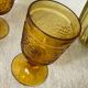 Six amber-colored stemmed glasses