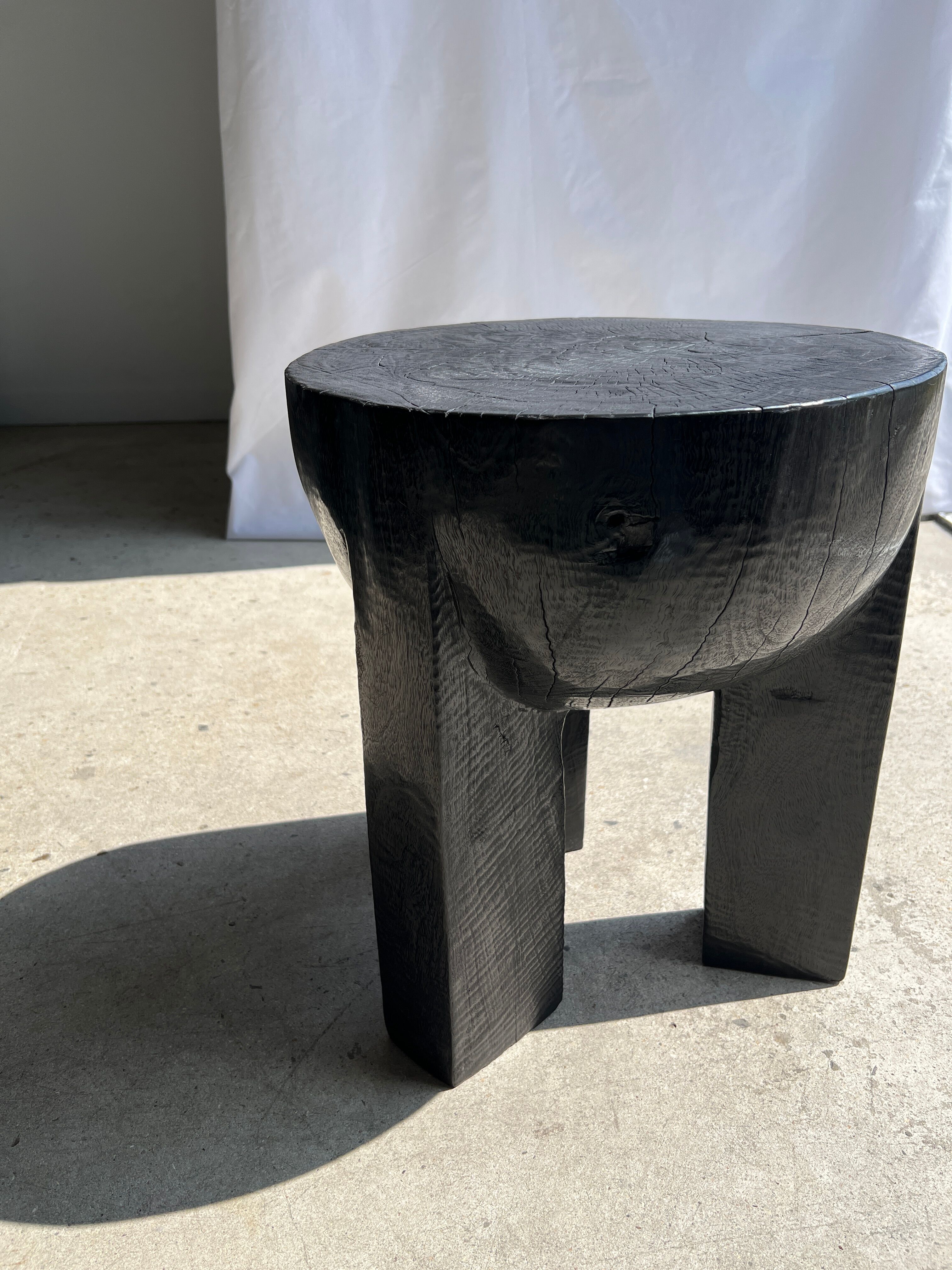 Black mango wood tripod side table with a semi-spherical top, height: 45 cm, diameter: 44 cm.