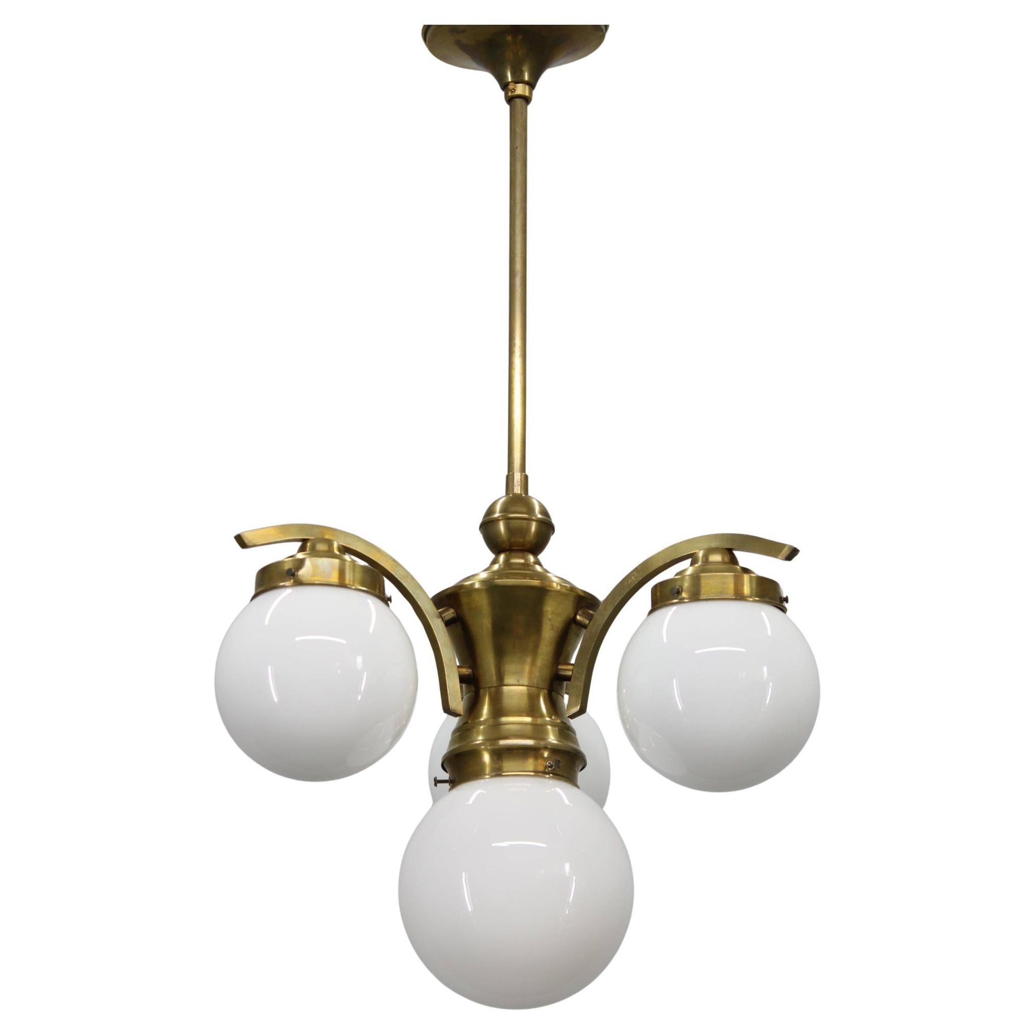 1930s Czechoslovak Art Deco brass chandelier with four opaline glass globes