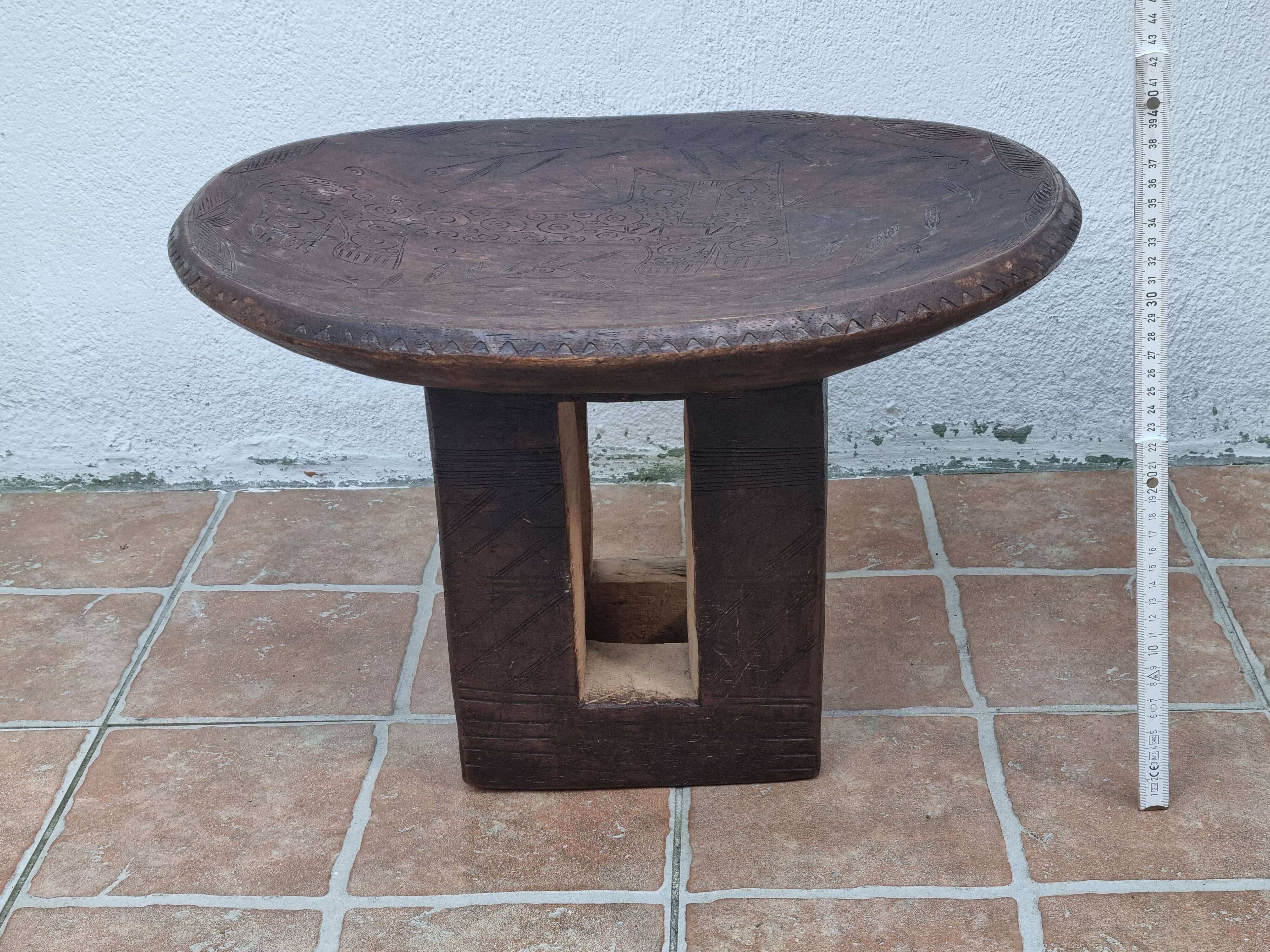 African monoxyle side table in carved wood with a curved top, 48x36 cm.