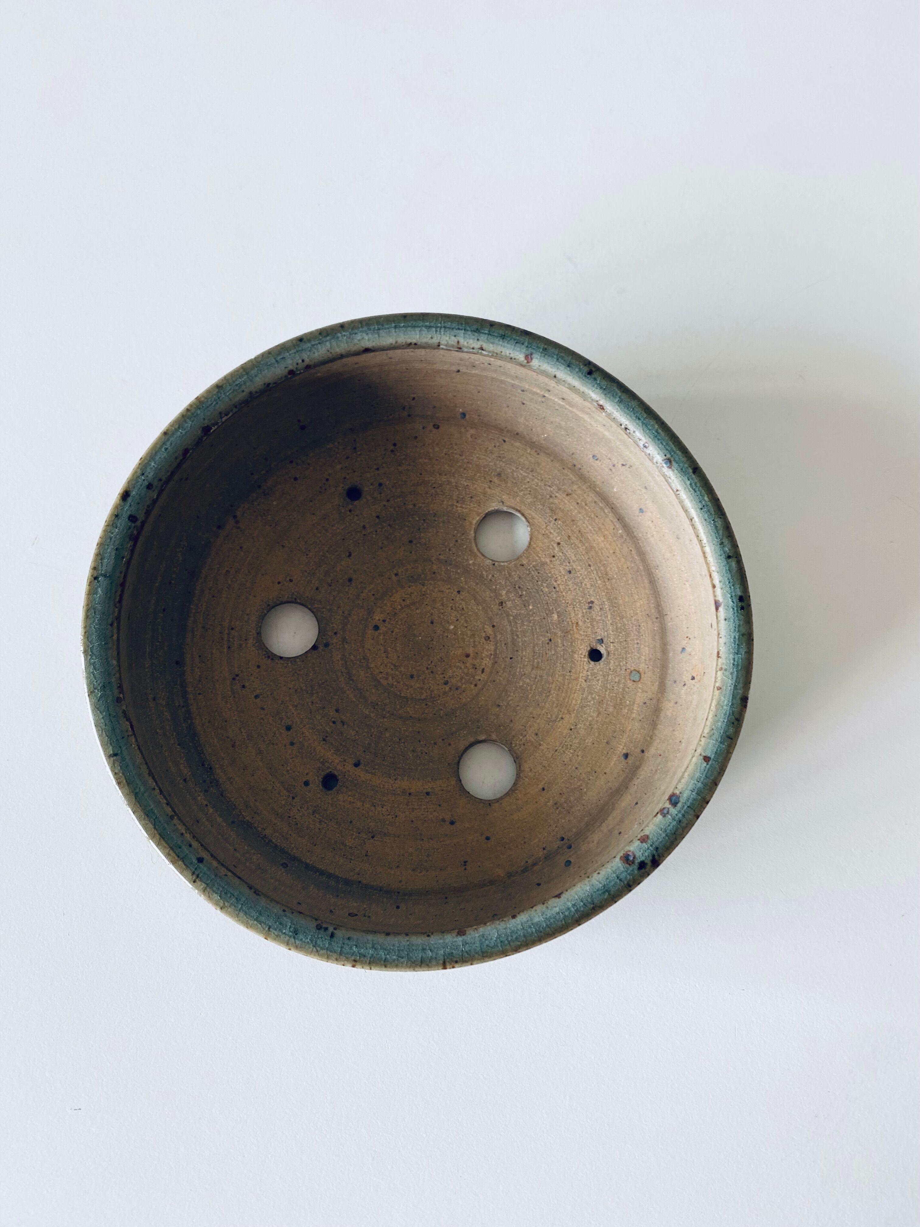 Pierced glazed stoneware cup