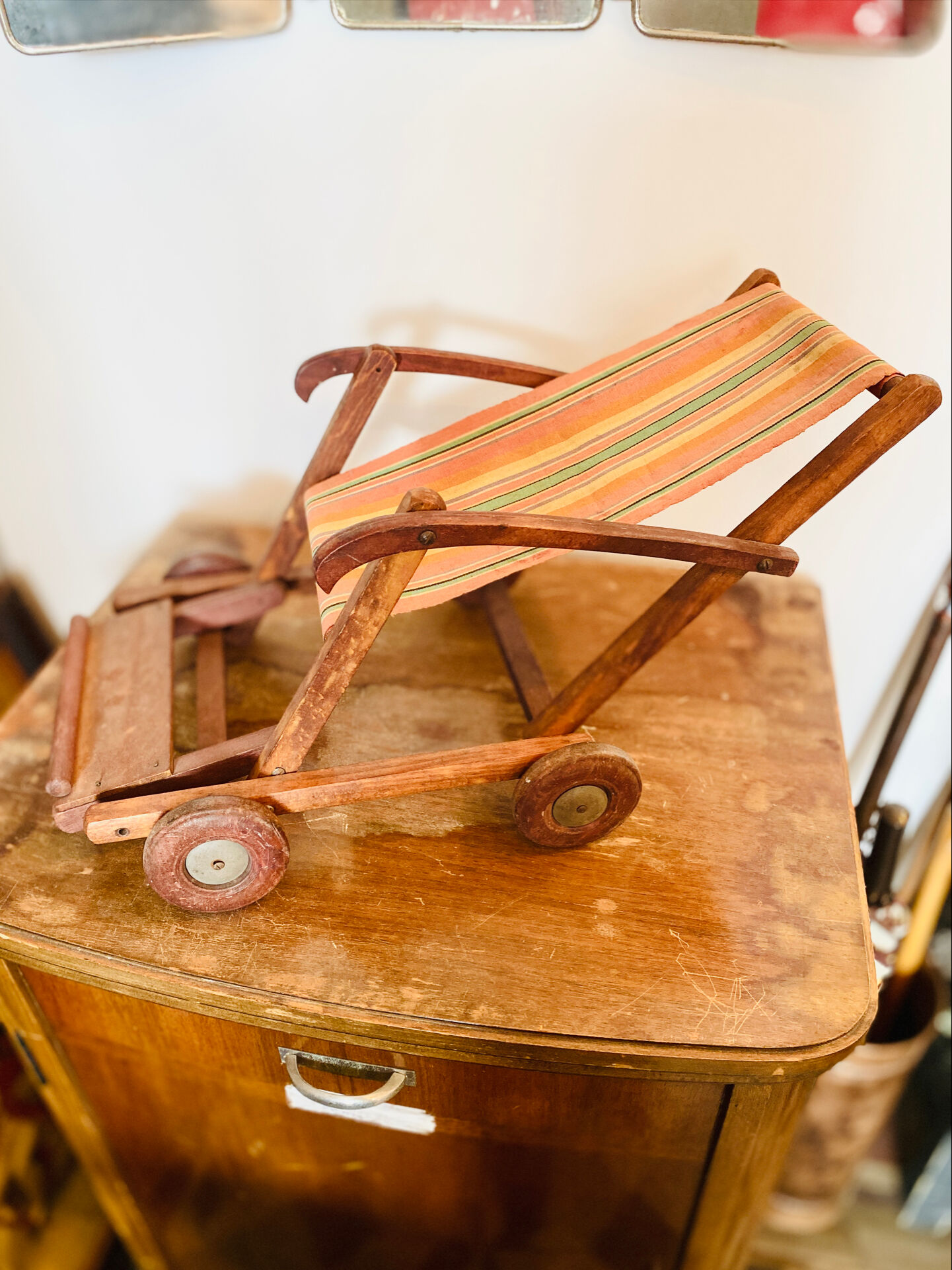 Vintage wooden folding doll's deckchair on wheels