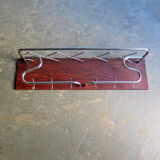 Chrome metal patere in a wooden support panel coat veneer.