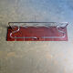 Chrome metal patere in a wooden support panel coat veneer.