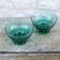 Set of 2 dark green crystal bowls.
