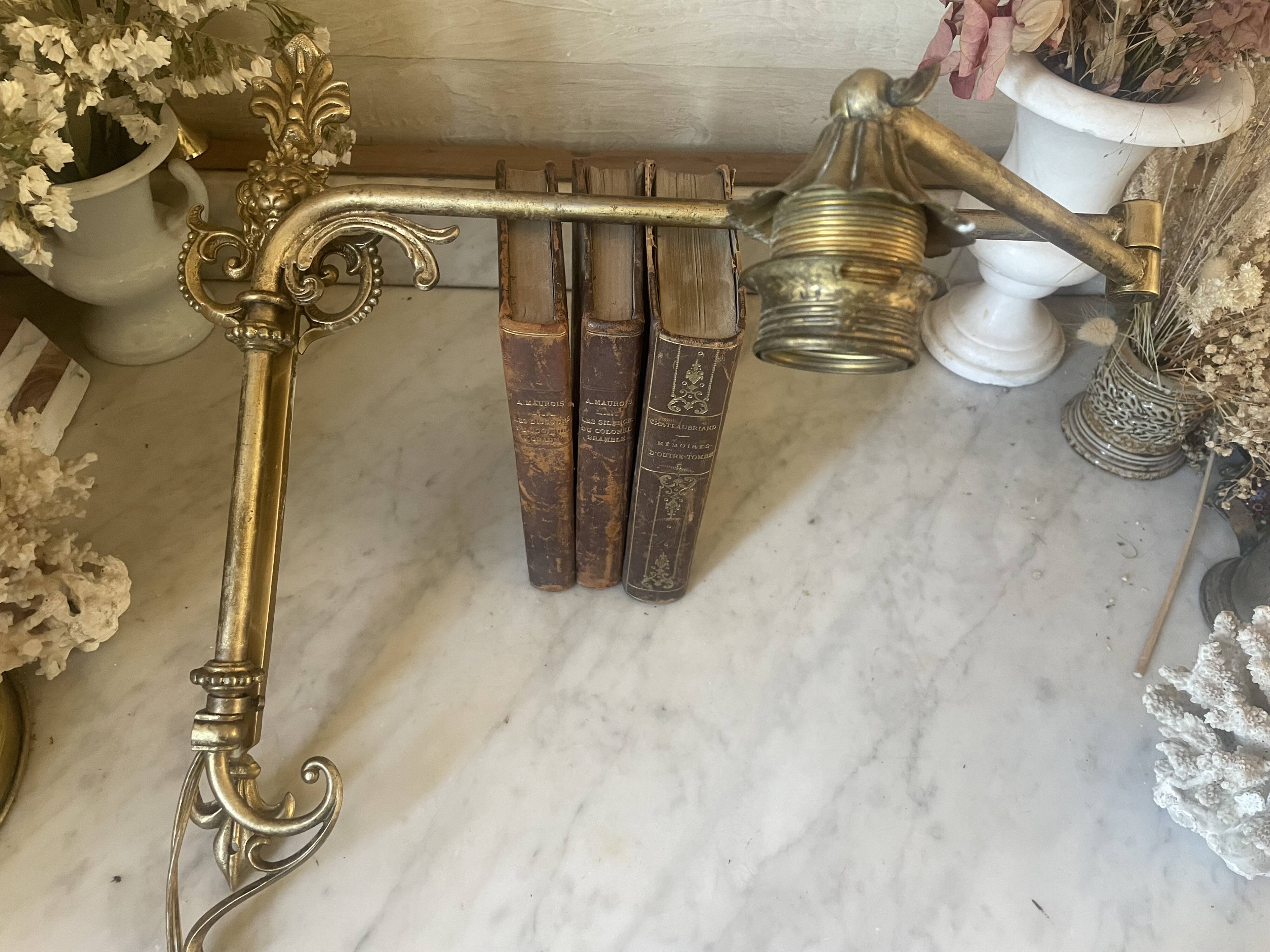 Adjustable wall light in brass and gold metal.