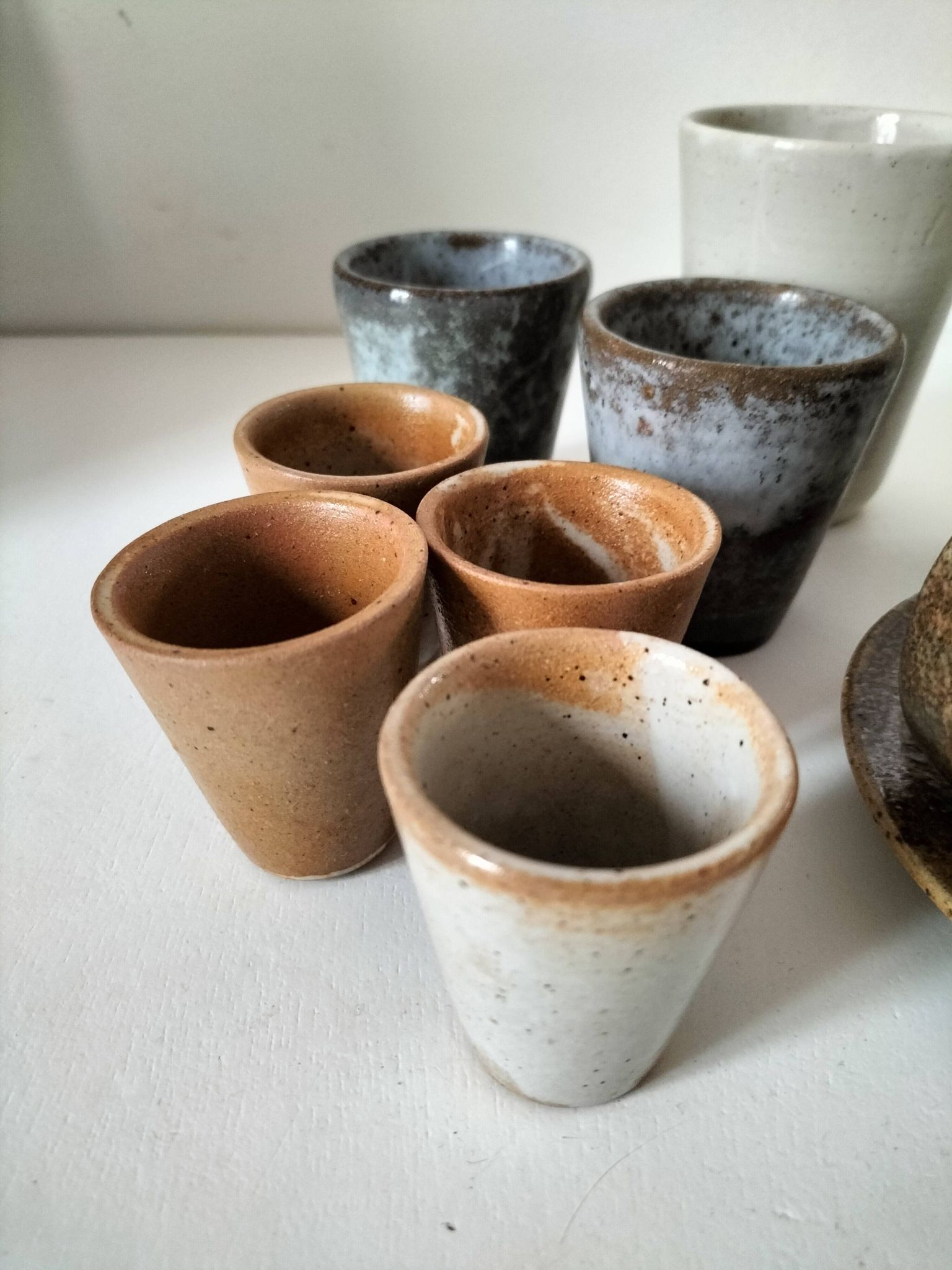 Set of 8 stoneware cups and a mug, shades of beige.