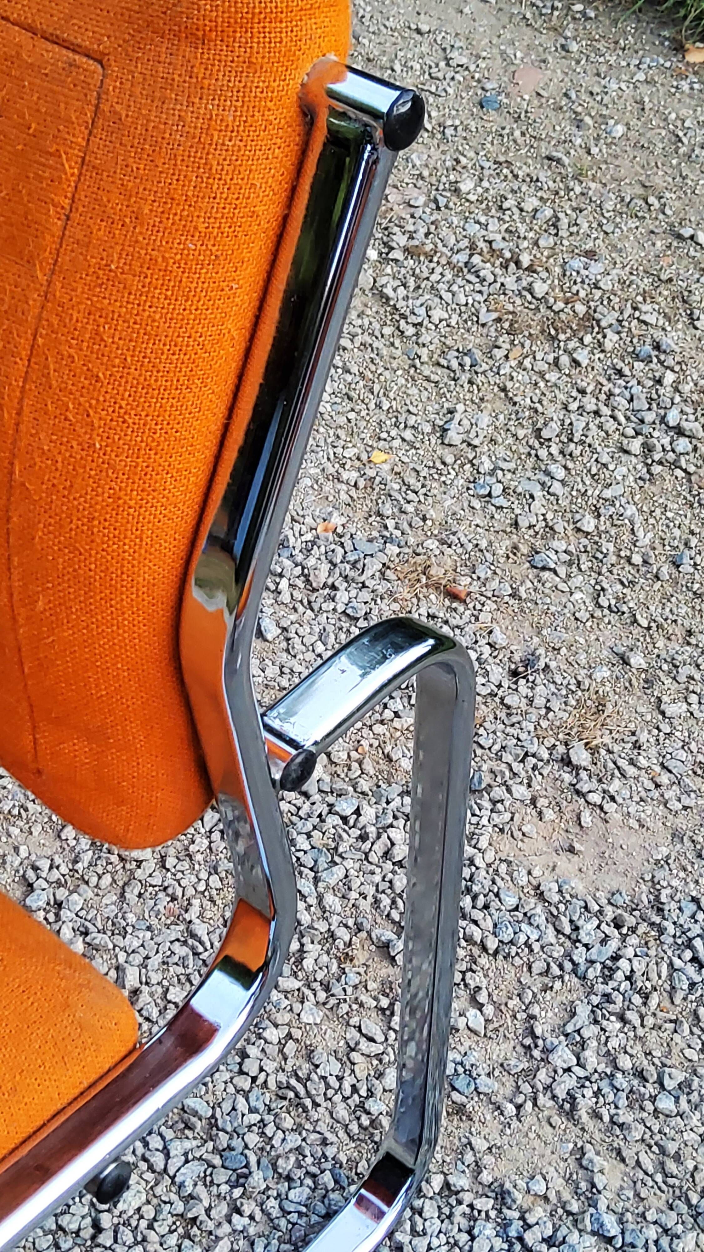 Pair of designer armchairs in orange fabrics and chrome tubes from the 70s