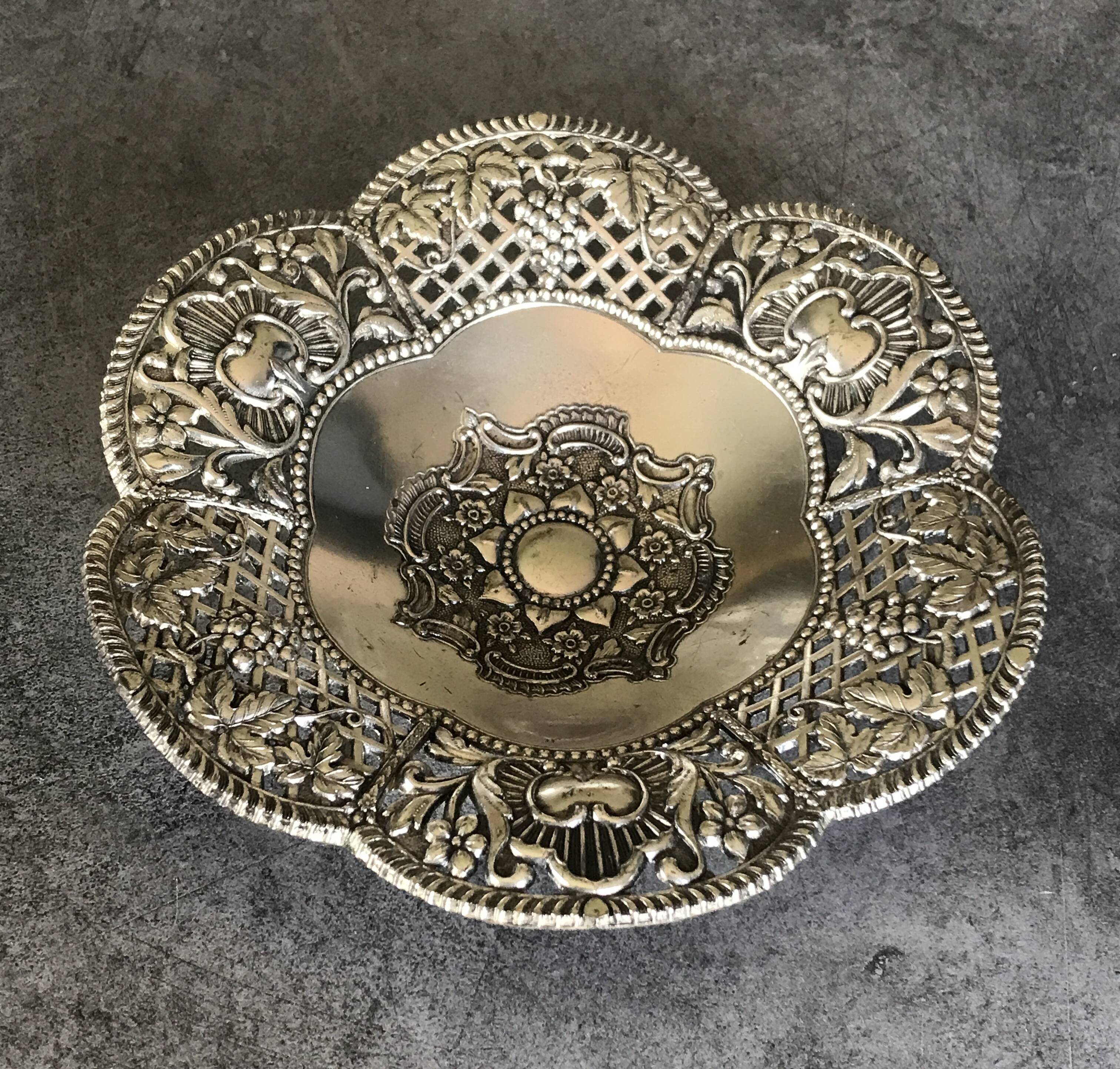 Silver-plated metal pocket emptier with openwork outline decoration