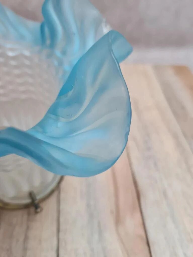 An antique lampshade in frosted glass with delicate blue edges.