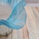 An antique lampshade in frosted glass with delicate blue edges.