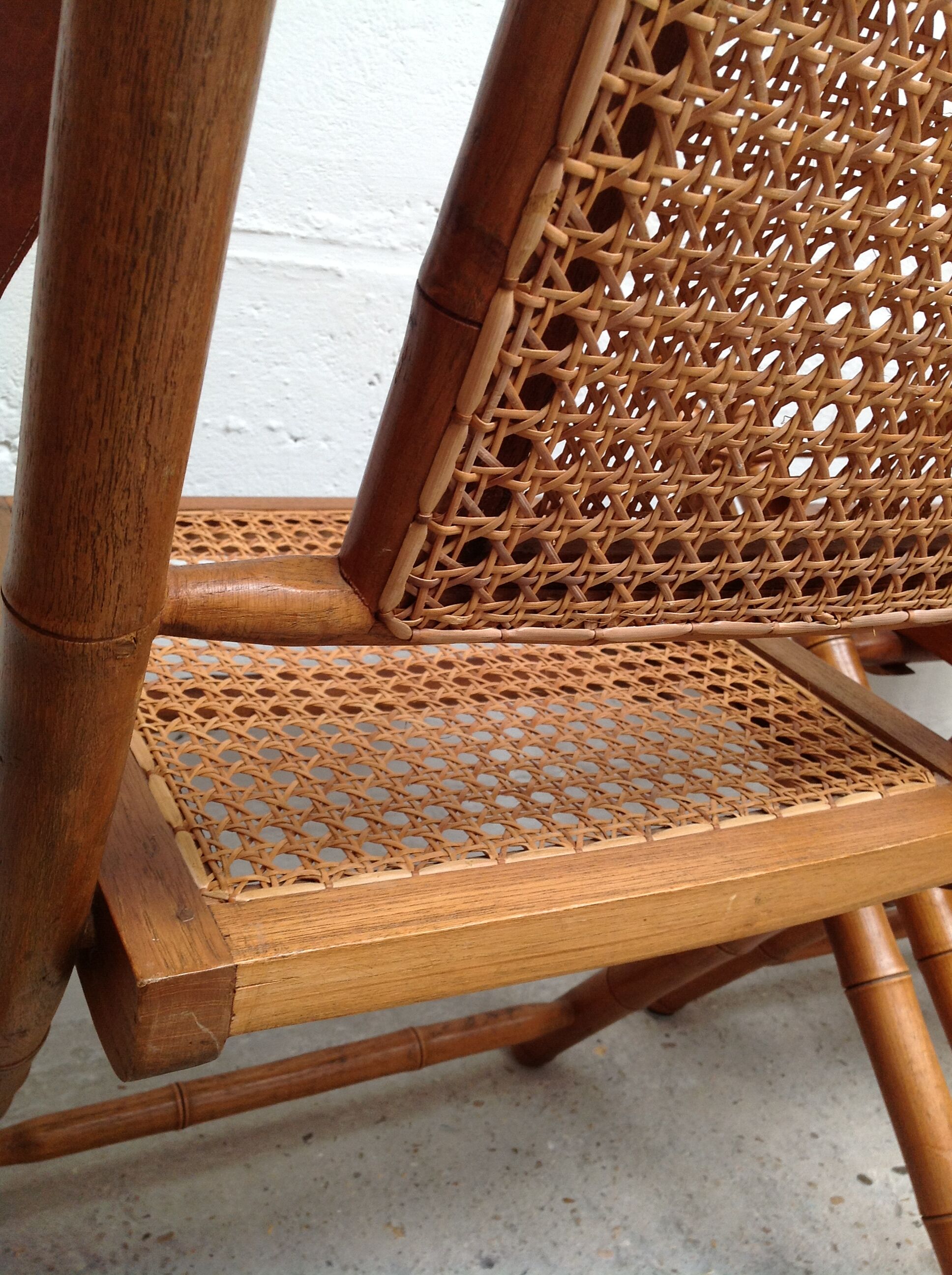 Pair of folding chairs in bamboo and caning, leather and brass