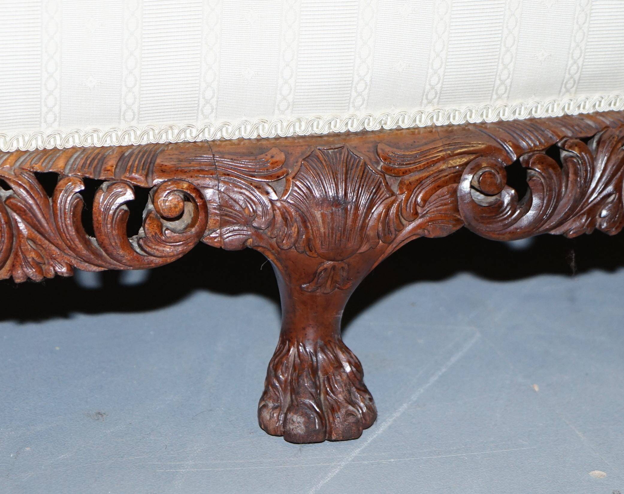 Three-seater canapé carved from solid walnut with claw feet.