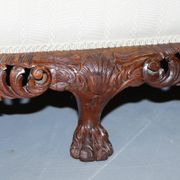 Three-seater canapé carved from solid walnut with claw feet.