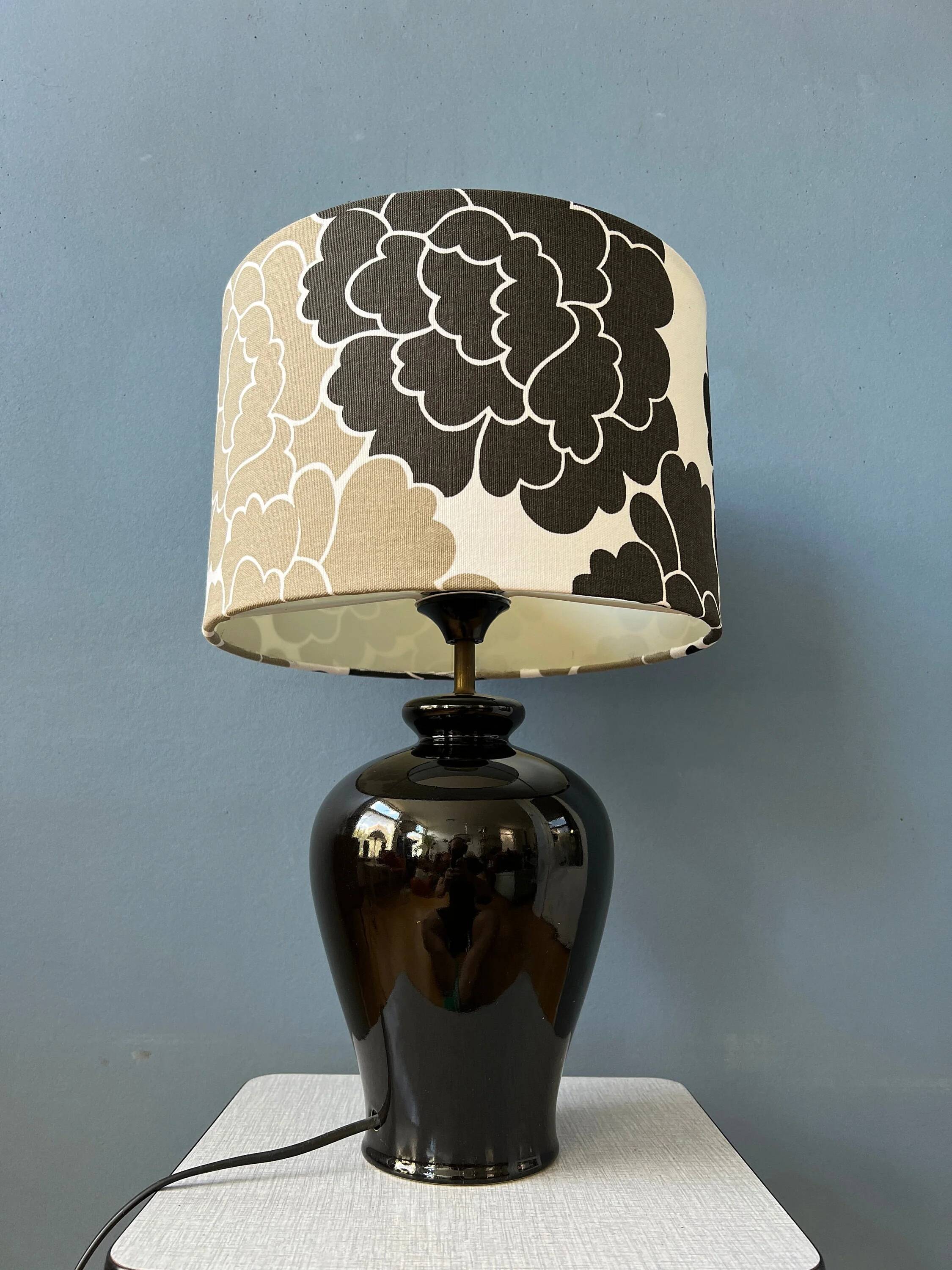 Small Space Age table lamp with a porcelain base and black and white flower shade.