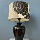Small Space Age table lamp with a porcelain base and black and white flower shade.