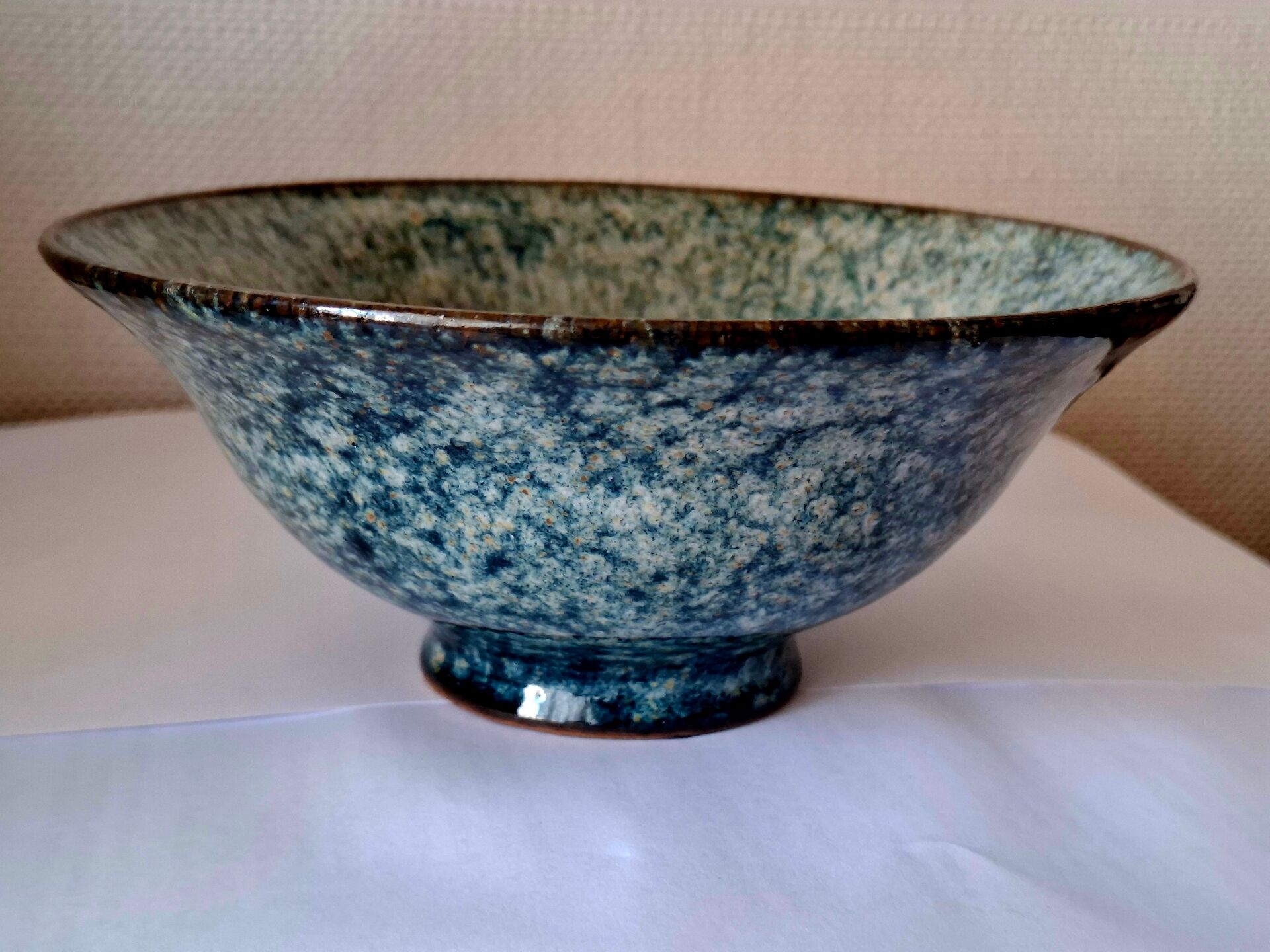 Bowl on a circular base or small blue ceramic dish.