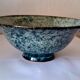 Bowl on a circular base or small blue ceramic dish.