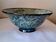 Bowl on a circular base or small blue ceramic dish.
